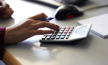 Une main avec une calculatrice électrique Une main avec une calculatrice électrique